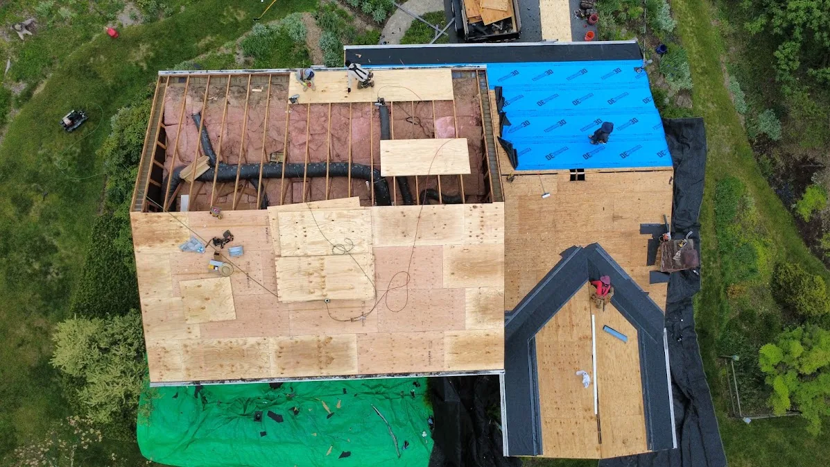 Roof stripped to the rafters with new plywood decking going down and a tarp protecting the yard below