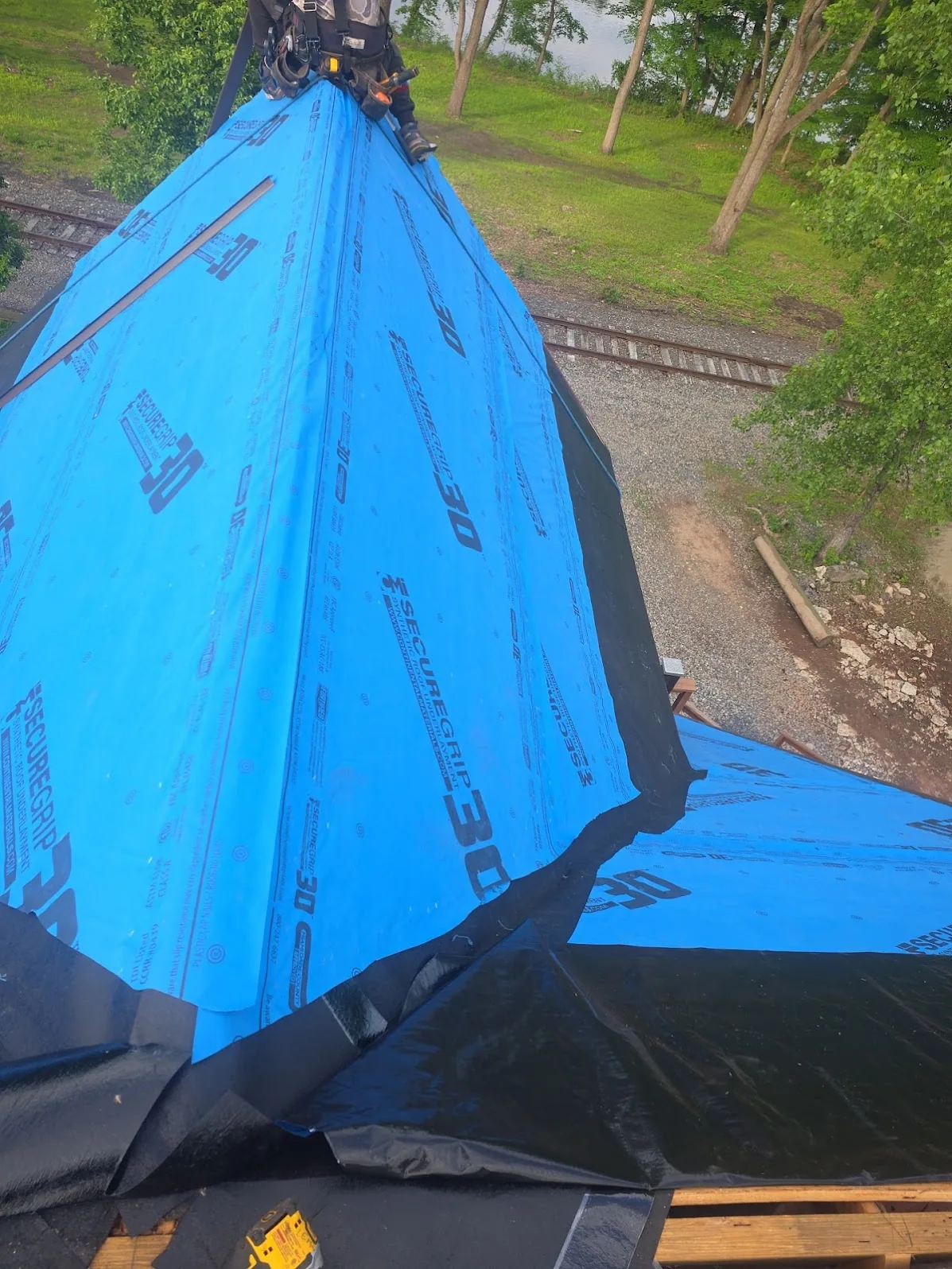 Roof deck fully dried in with synthetic underlayment and a self-adhering ice-and-water membrane running down the valley