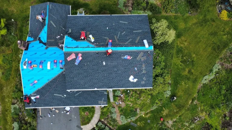 Aerial view of a roof mid-replacement, half covered in new shingles and half in underlayment, with no bare decking exposed